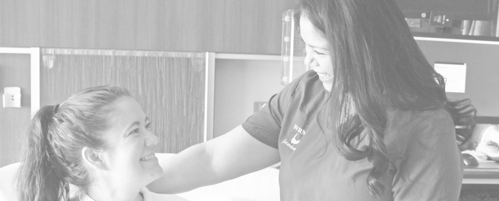 Black and white photo of BVRMC employee with an OB patient